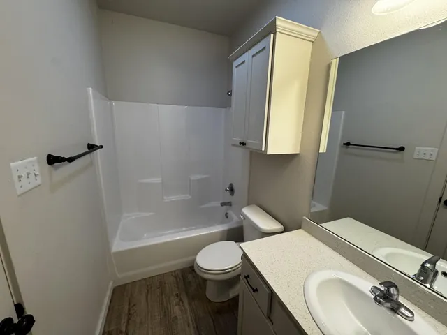a bathroom with a granite countertop sink toilet a mirror and shower