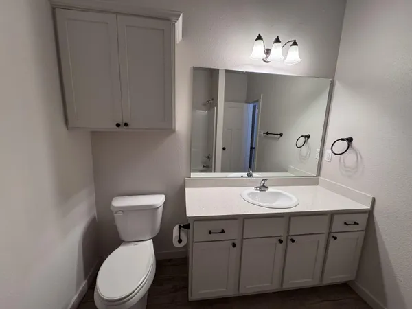 a bathroom with a toilet sink and mirror