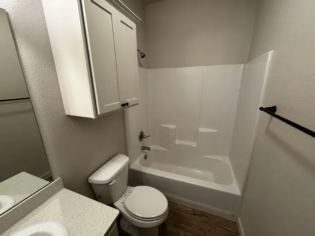 a white toilet sitting next to a bath tub
