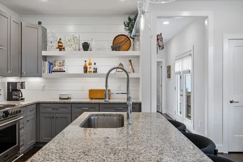 a kitchen with stainless steel appliances granite countertop a sink stove and refrigerator