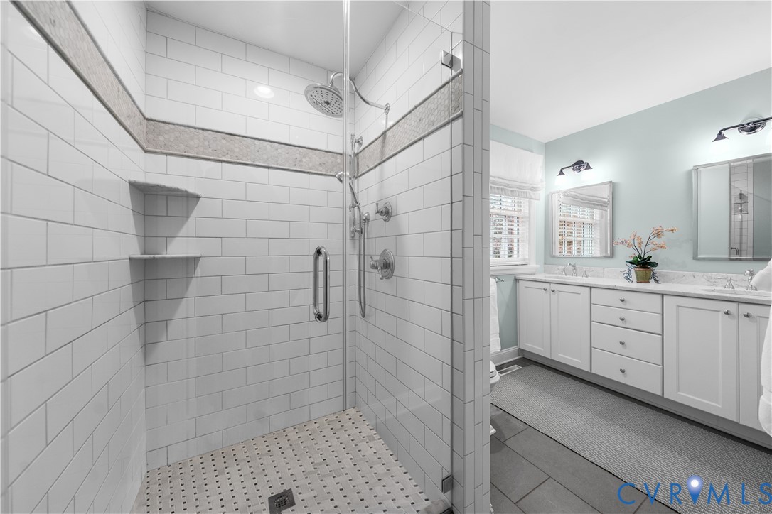 8101 Longwood Road Henrico, VA 23229 - Photo 20 of 49 a bathroom with a double vanity sink a toilet and shower