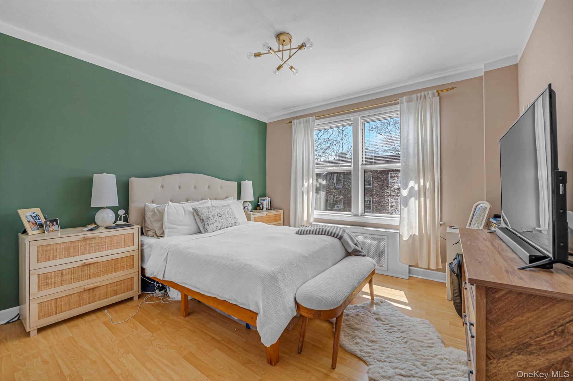 141-45 78th Road, Unit 3A Queens, NY 11367 - Photo 8 of 17 Bedroom with light wood-style floors, crown molding, baseboards, and an inviting chandelier
