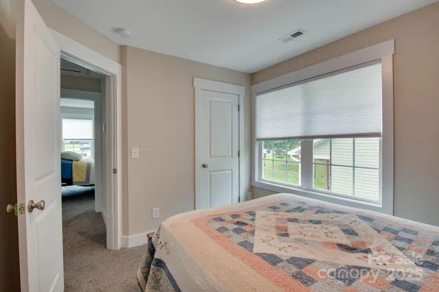 a bedroom with a bed and a large window