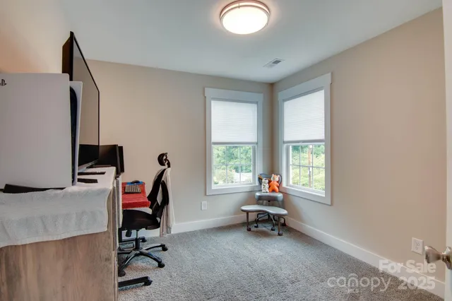 a view of a workspace with furniture and a window