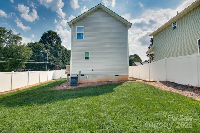 a view of yard with small cabin and wooden fence