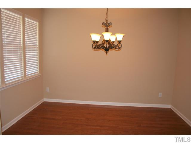 7862 Cape Charles Drive Raleigh, NC 27617 - Photo 8 of 12 a view of a room with wooden floor and chandelier