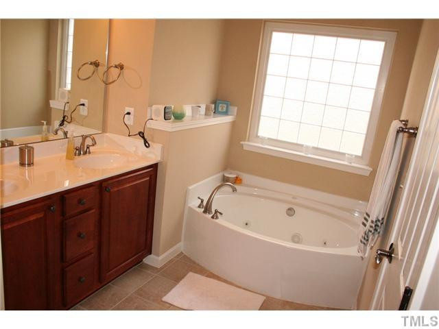 7862 Cape Charles Drive Raleigh, NC 27617 - Photo 10 of 12 a bathroom with a tub sink and mirror
