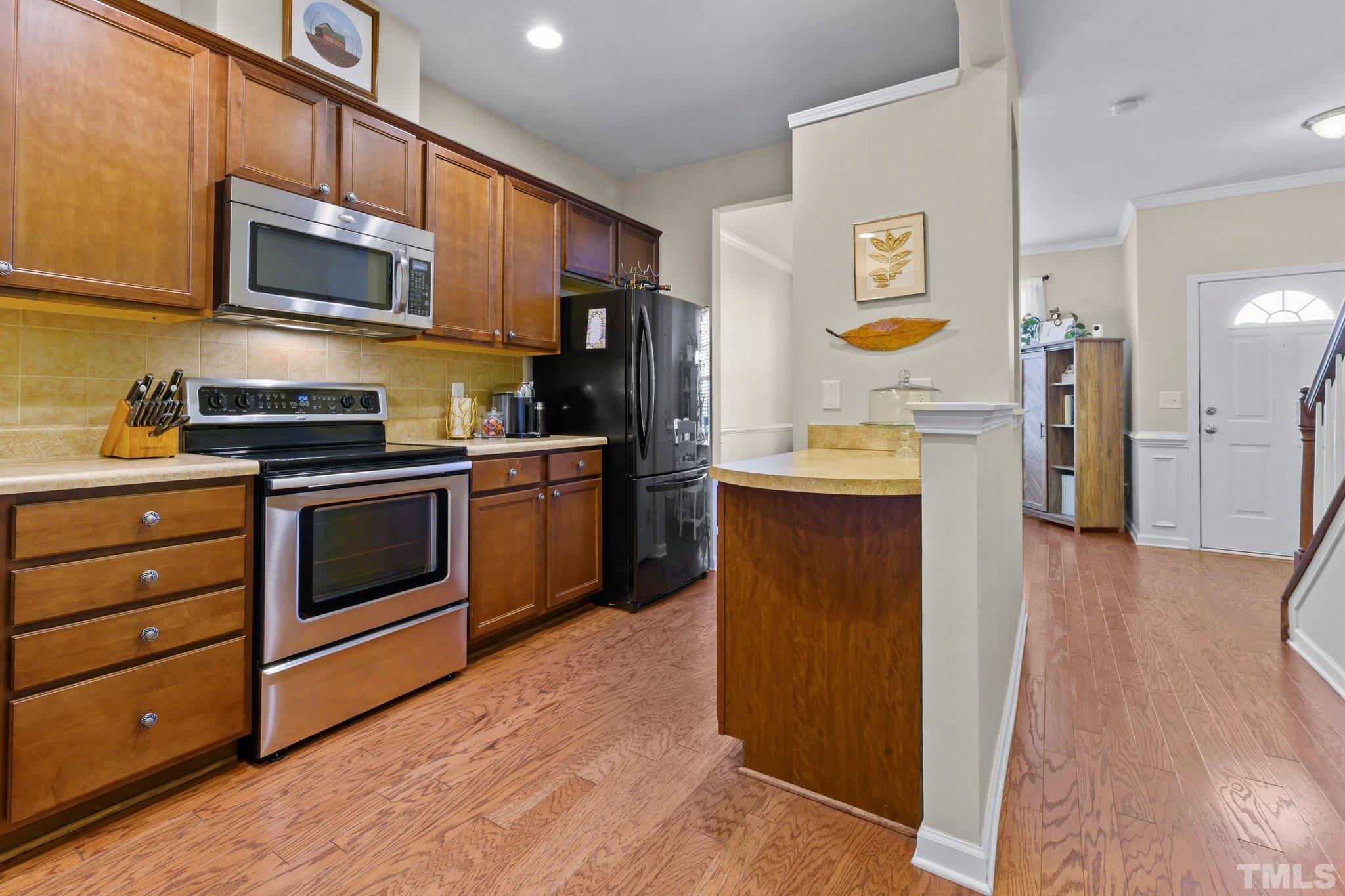 2842 Casona Way Raleigh, NC 27616 - Photo 6 of 27 a kitchen with stainless steel appliances a stove a sink and a refrigerator