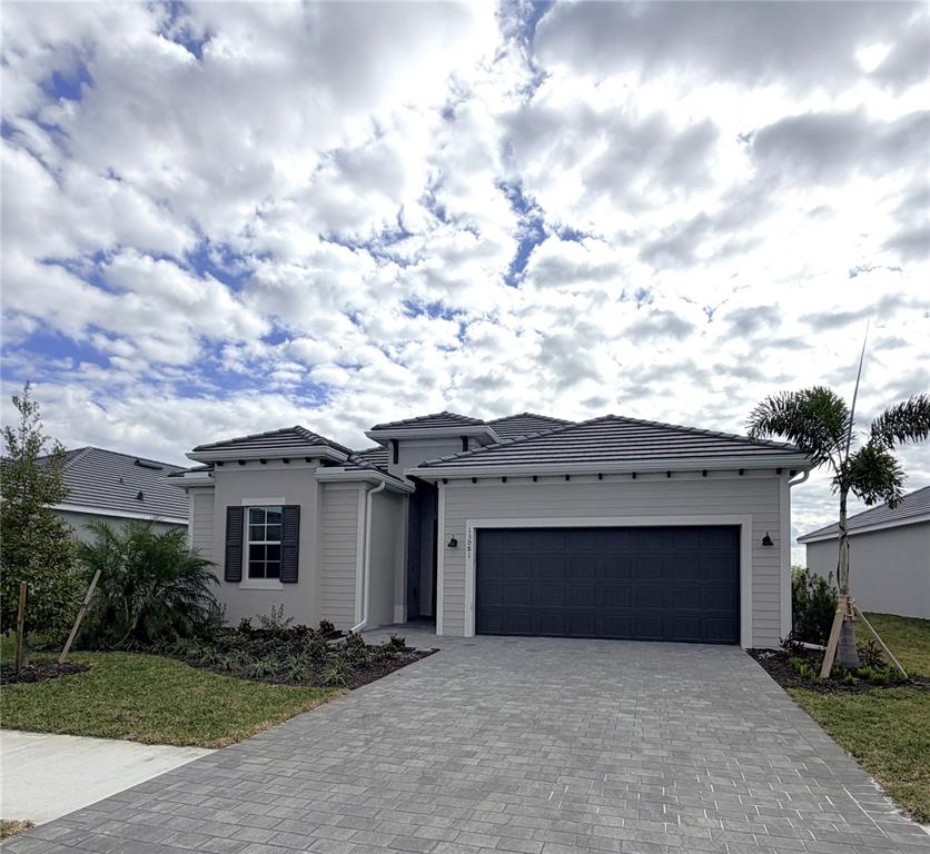 13081 Tulum Loop Venice, FL 34293 - Photo 1 of 48 a front view of a house with a yard and garage