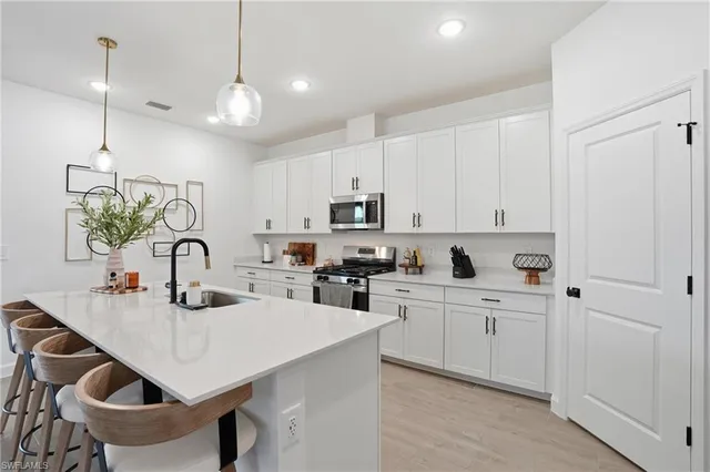 a kitchen with sink a microwave and cabinets