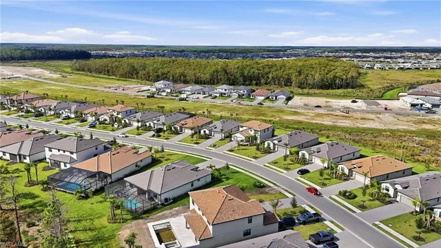an aerial view of a city with lots of residential buildings and ocean view in back