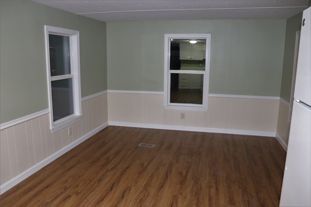 557 Southwest Cutoff, Unit 120 Worcester, MA 01607 - Photo 8 of 17 an empty room with wooden floor and windows