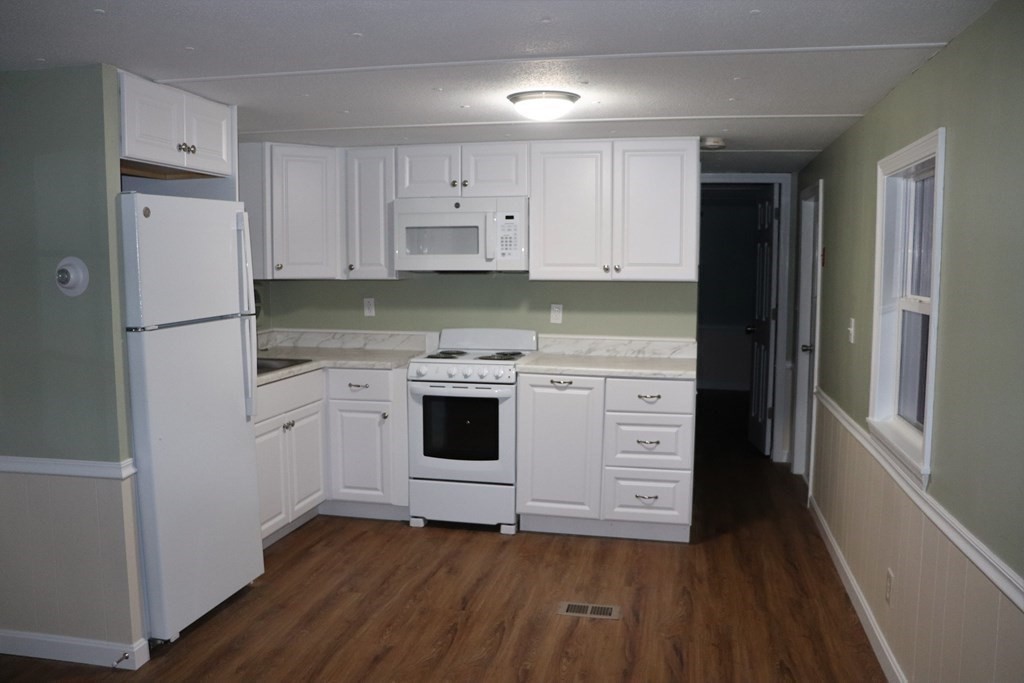 557 Southwest Cutoff, Unit 120 Worcester, MA 01607 - Photo 10 of 17 a kitchen with white cabinets and white appliances