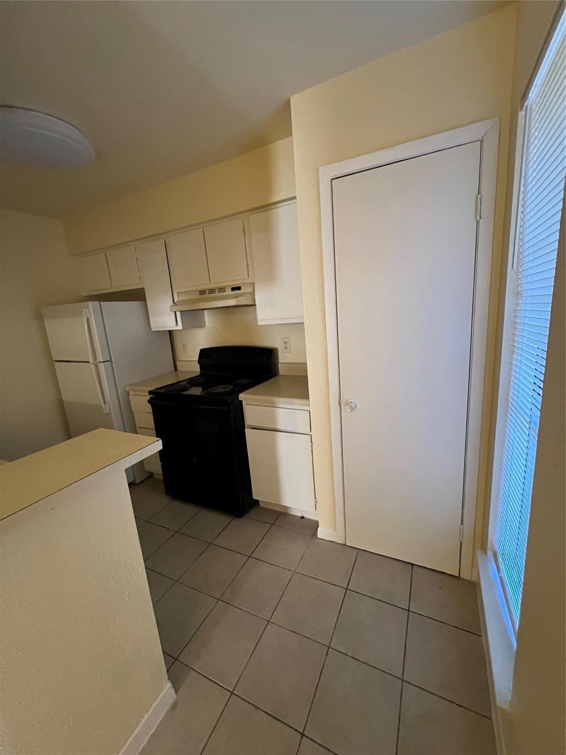 9000 Bissonnet Street, Unit 705 Houston, TX 77074 - Photo 11 of 18 a kitchen with a refrigerator and cabinets