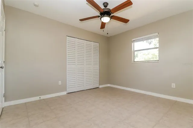 an empty room with a window and a fan