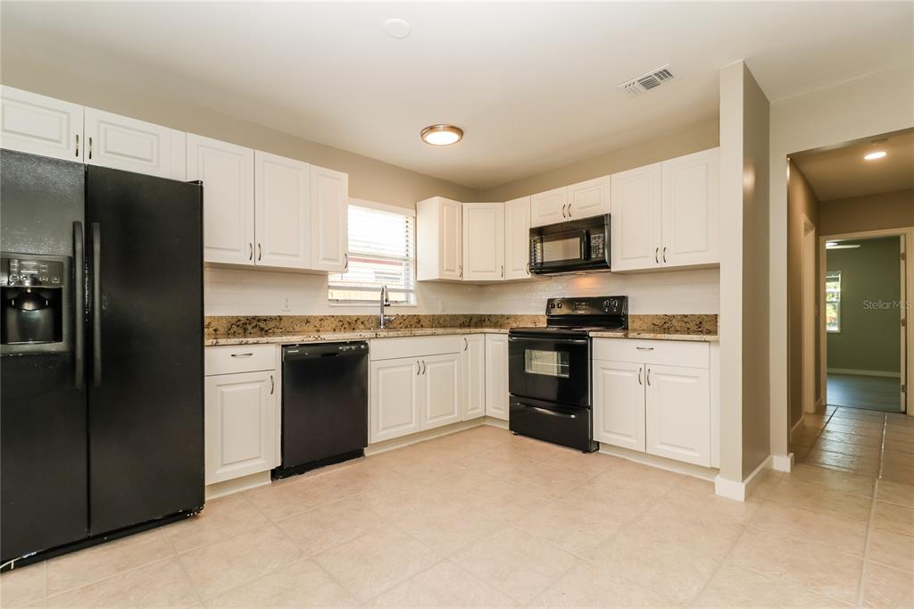 9537 Groveland Street Seminole, FL 33772 - Photo 5 of 16 a kitchen with a refrigerator stove and microwave