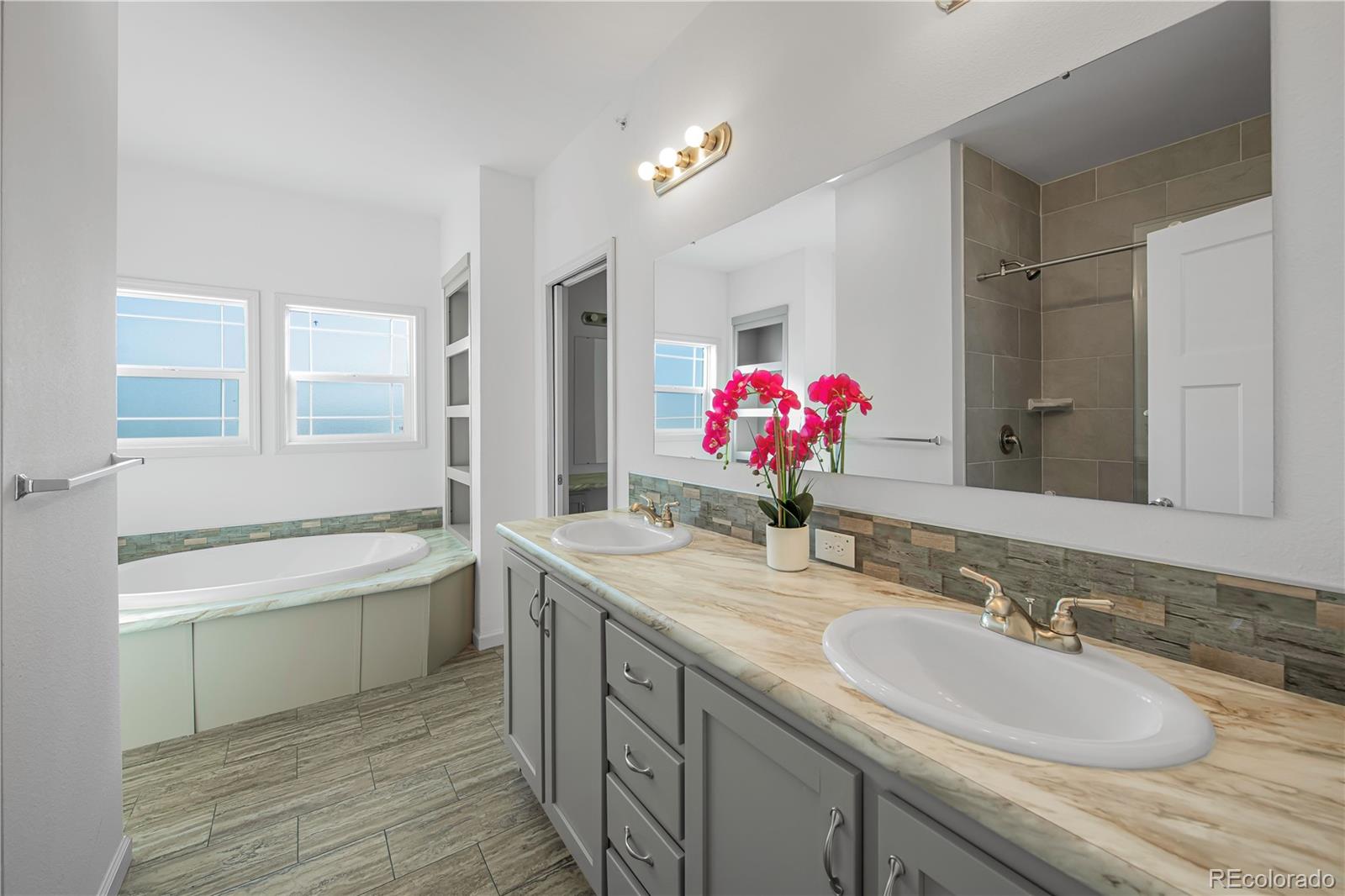 6 Timberlake Road Byers, CO 80103 - Photo 10 of 18 a bathroom with a granite countertop sink a large mirror and a bathtub