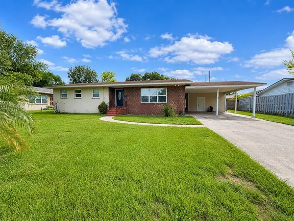 a view of a house with a yard and sitting area