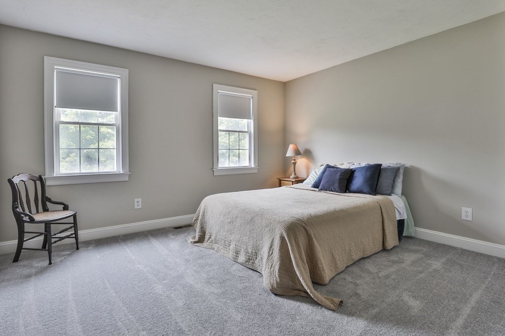 4 Breezy Point Road Acton, MA 01720 - Photo 30 of 40 a bedroom with a bed and chair next to a window