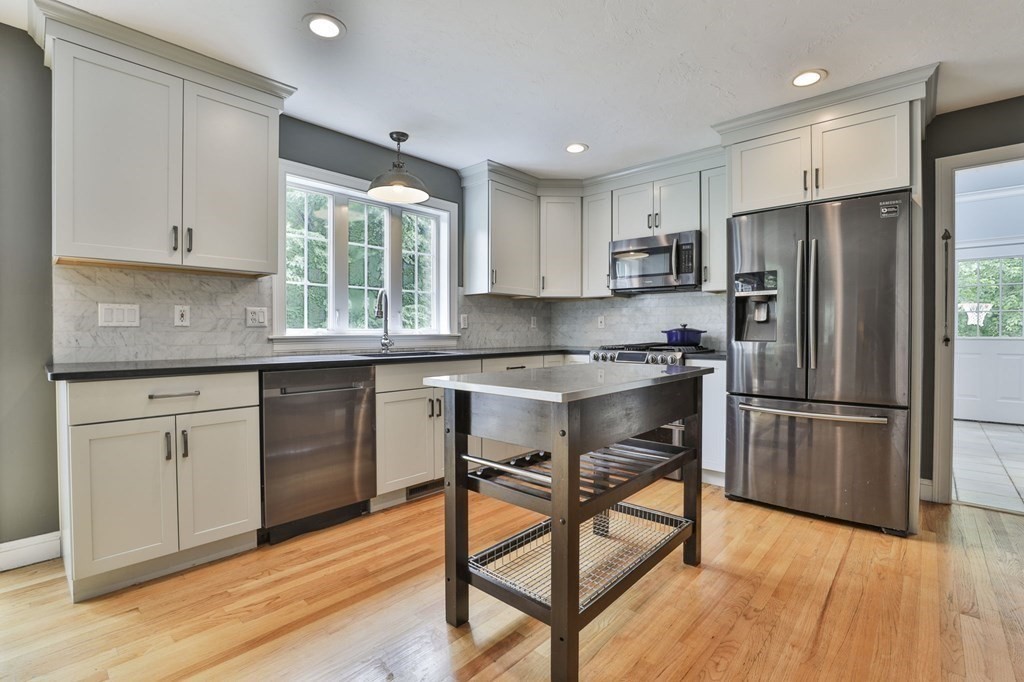 4 Breezy Point Road Acton, MA 01720 - Photo 4 of 40 a kitchen with a refrigerator a sink dishwasher a stove and white cabinets with wooden floor