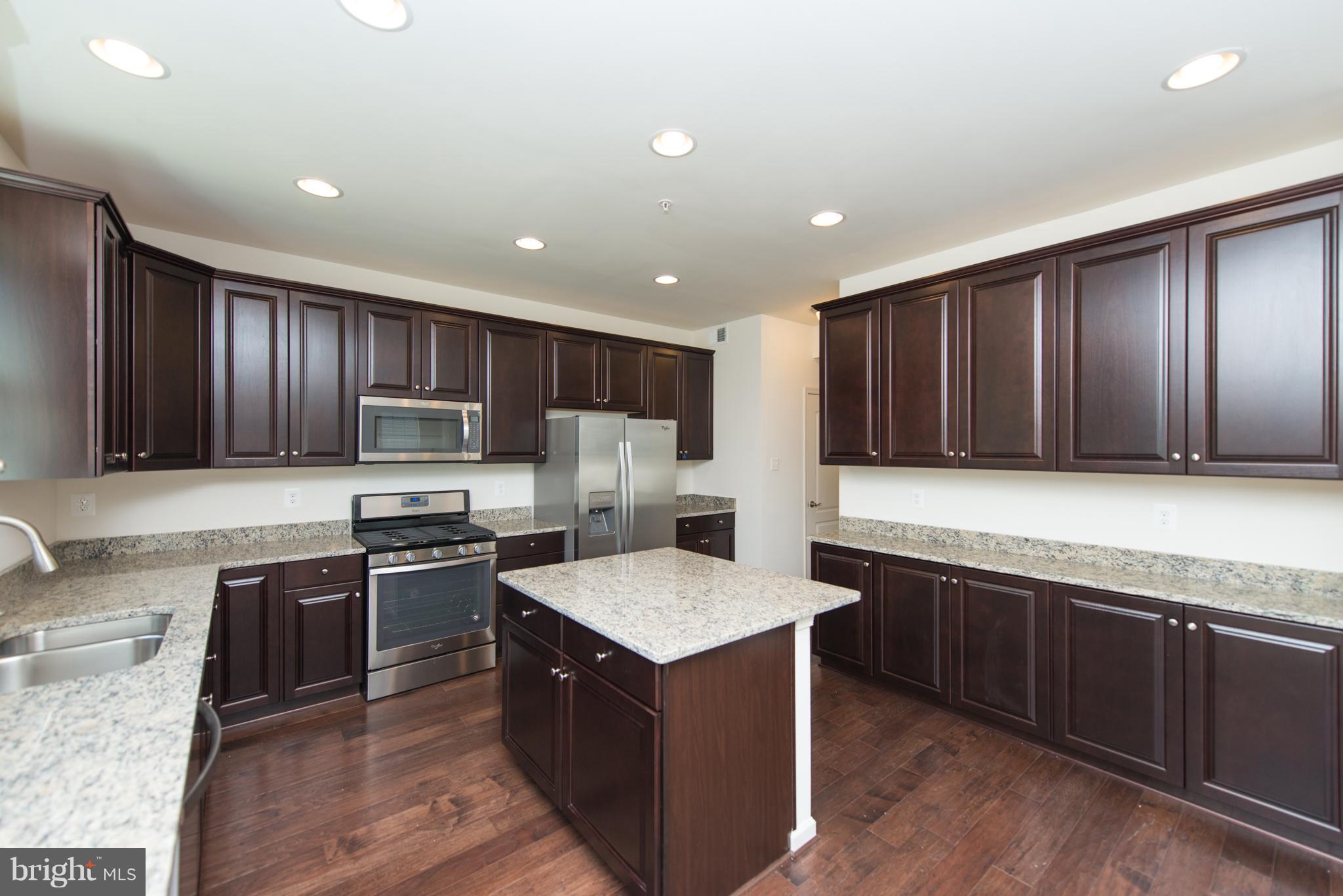 910 Ramble Run Road Baltimore, MD 21220 - Photo 12 of 30 a kitchen with stainless steel appliances granite countertop wooden cabinets a stove top oven a sink and dishwasher