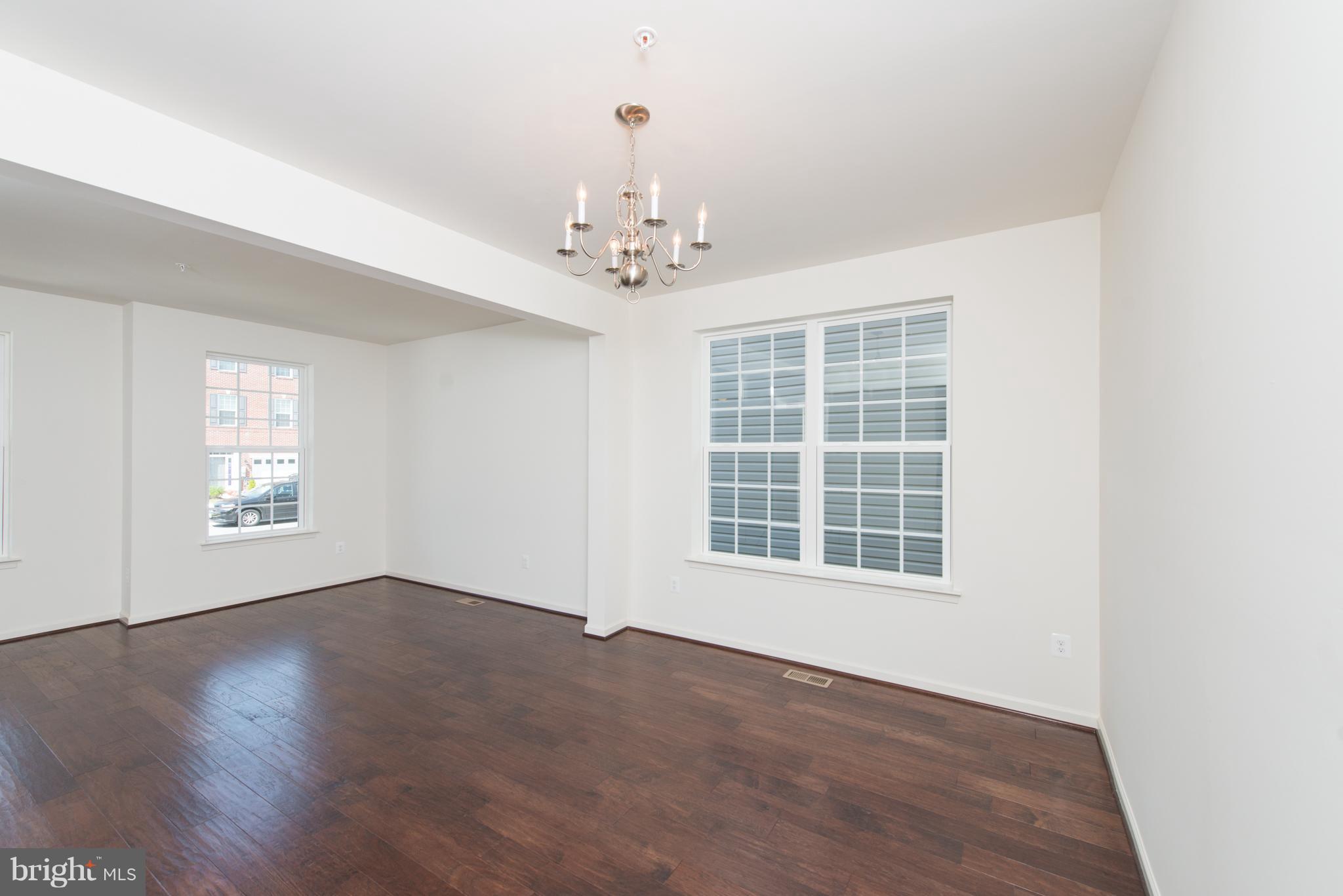 910 Ramble Run Road Baltimore, MD 21220 - Photo 4 of 30 a view of an empty room with a window and wooden floor