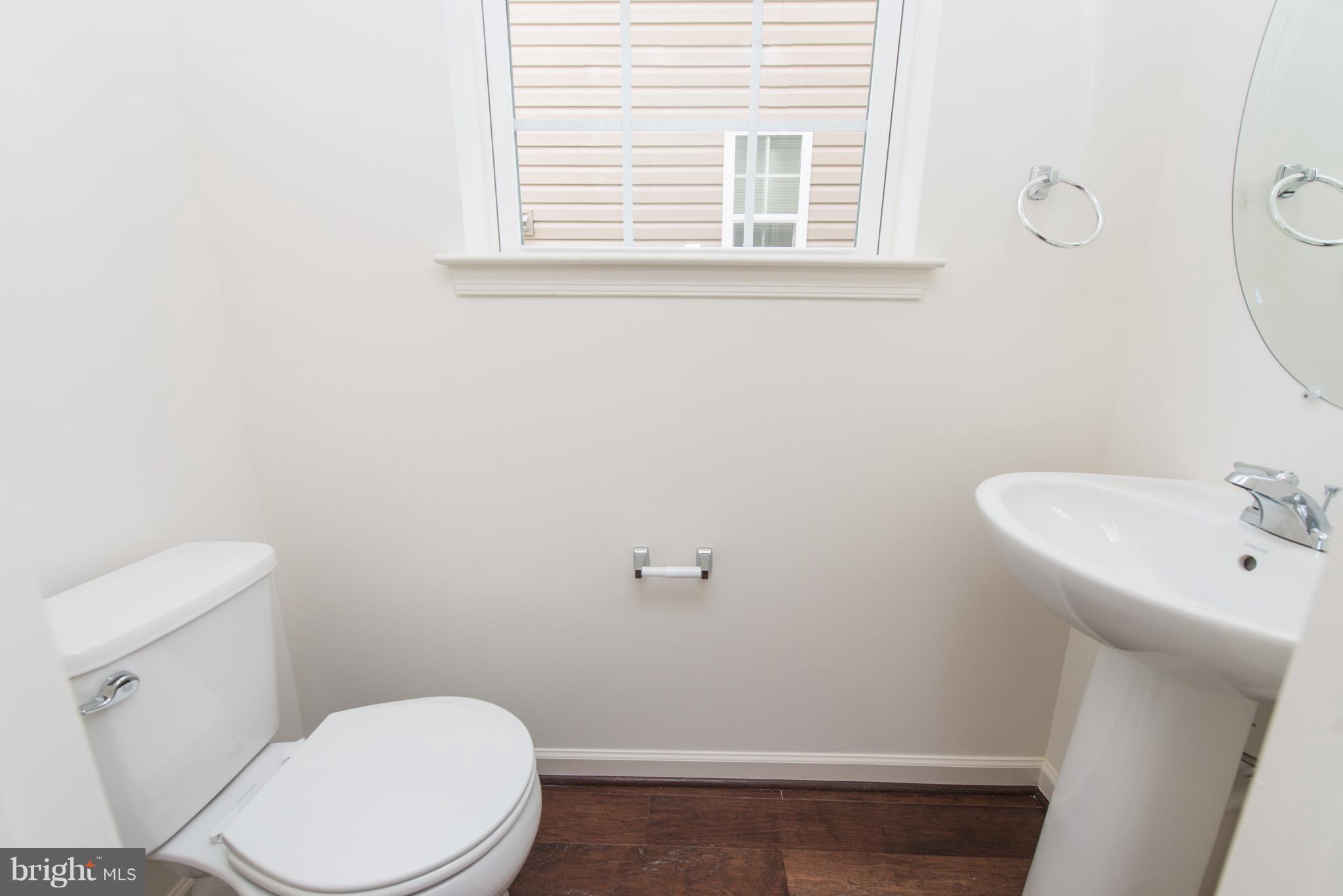 910 Ramble Run Road Baltimore, MD 21220 - Photo 6 of 30 a white toilet sitting next to a bathroom sink