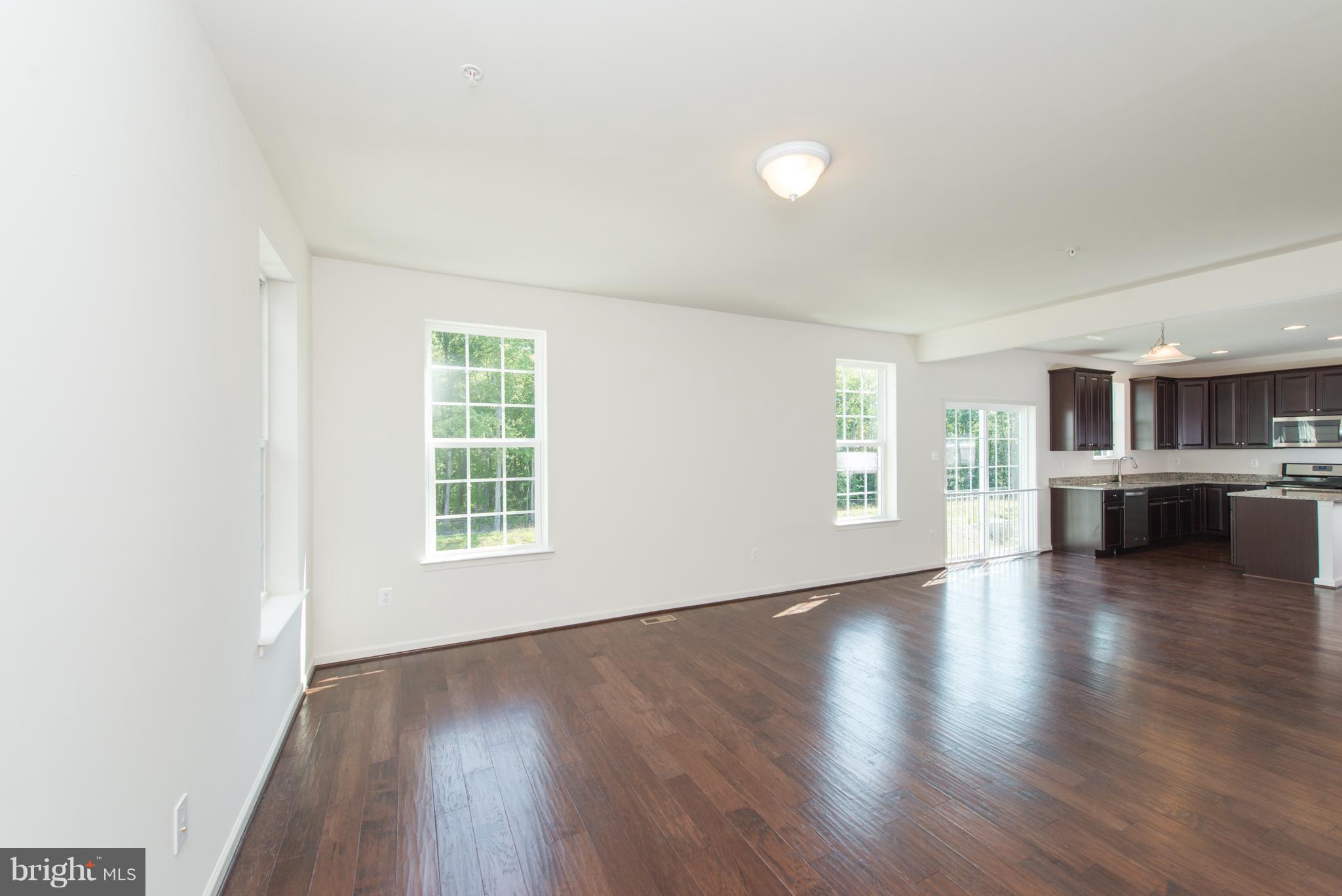 910 Ramble Run Road Baltimore, MD 21220 - Photo 7 of 30 a view of an empty room with a window and wooden floor