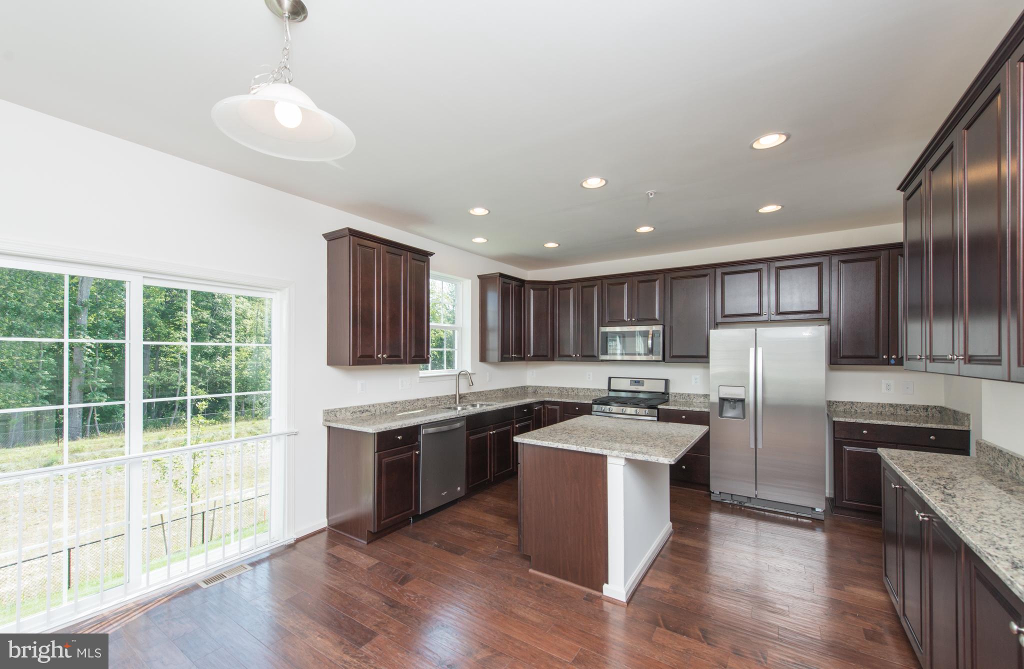 910 Ramble Run Road Baltimore, MD 21220 - Photo 9 of 30 a kitchen with stainless steel appliances granite countertop a stove top oven a sink and a refrigerator