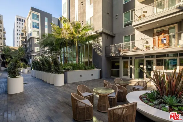 a view of a patio with couches table and chairs and potted plants