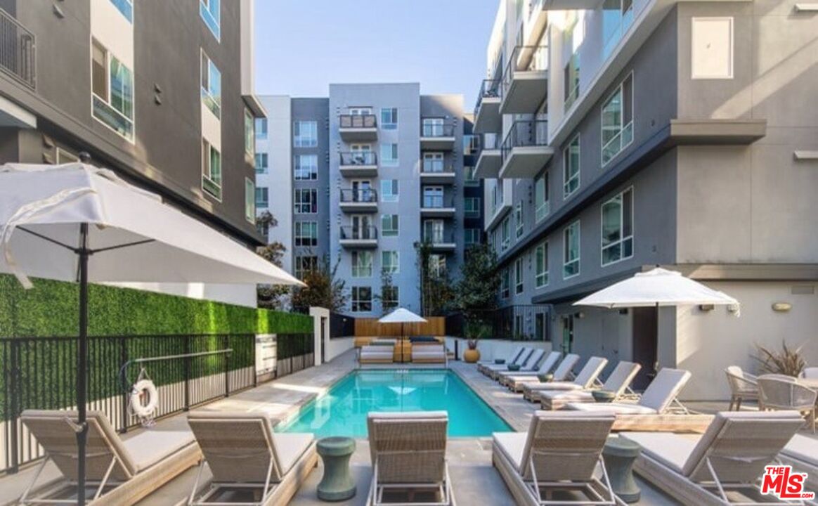 1120 West 6th Street, Unit 2151 Los Angeles, CA 90017 - Photo 49 of 51 a view of a patio with couches table and chairs under an umbrella