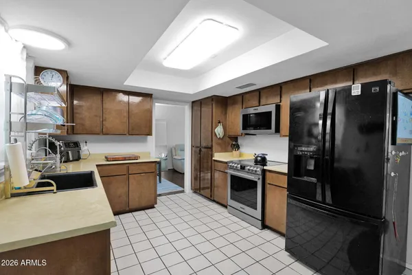 a kitchen with stainless steel appliances granite countertop a refrigerator sink and stove