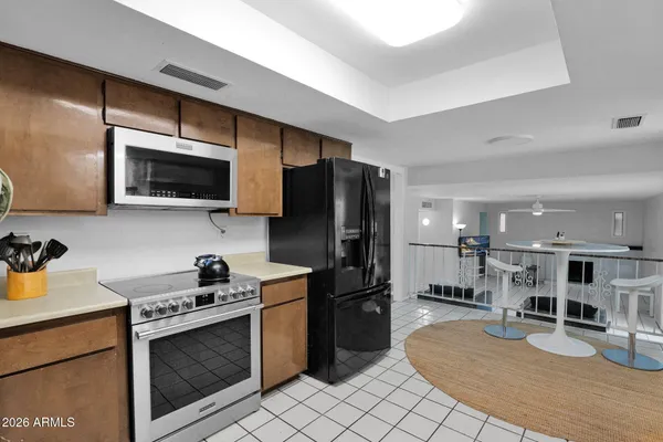 a kitchen with stainless steel appliances kitchen island granite countertop a stove a sink and a microwave