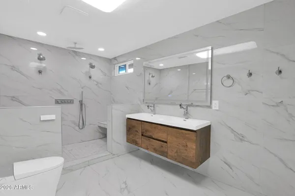 a bathroom with a sink a toilet and shower