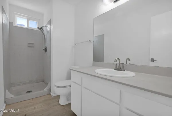 a bathroom with a granite countertop sink a toilet and shower