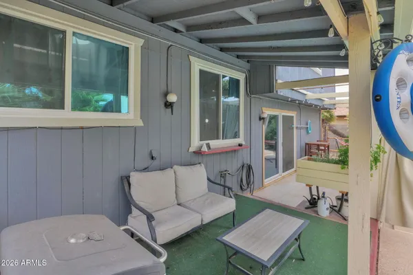 a view of a patio with table and chairs under an umbrella with a barbeque grill and plants