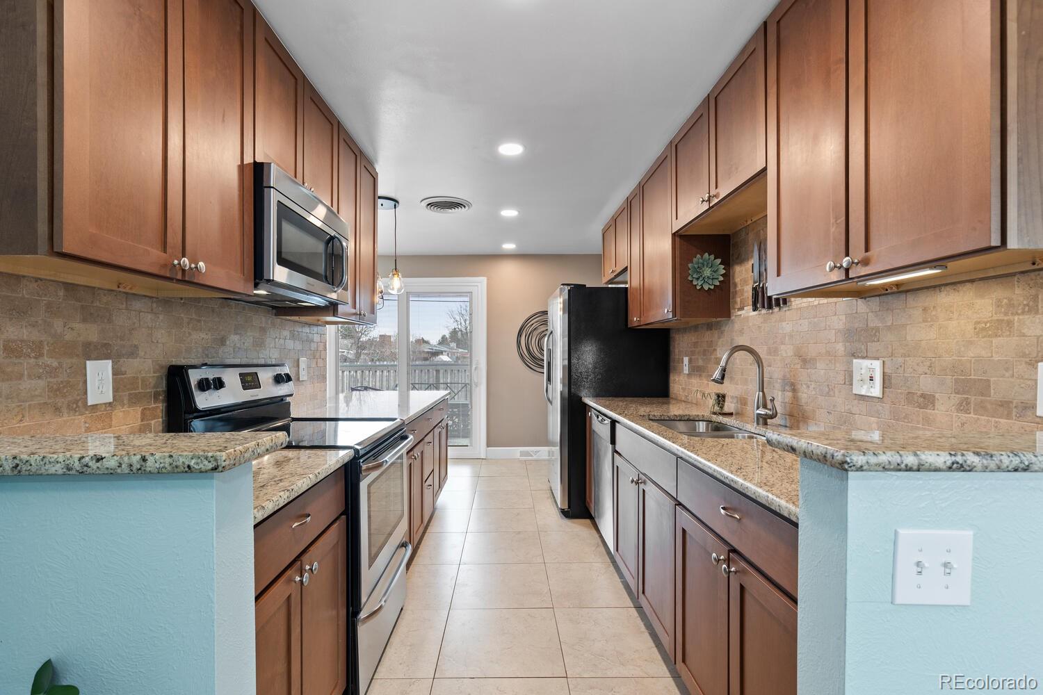 236 Lima Street Aurora, CO 80010 - Photo 6 of 50 a kitchen with stainless steel appliances granite countertop a sink a stove and a microwave