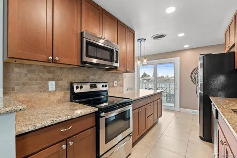 a kitchen with stainless steel appliances granite countertop a stove microwave and refrigerator