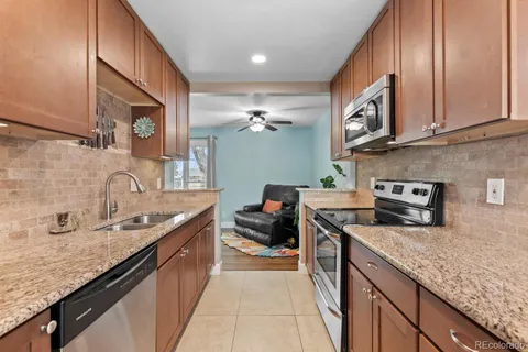 a kitchen with stainless steel appliances granite countertop a sink stove and cabinets