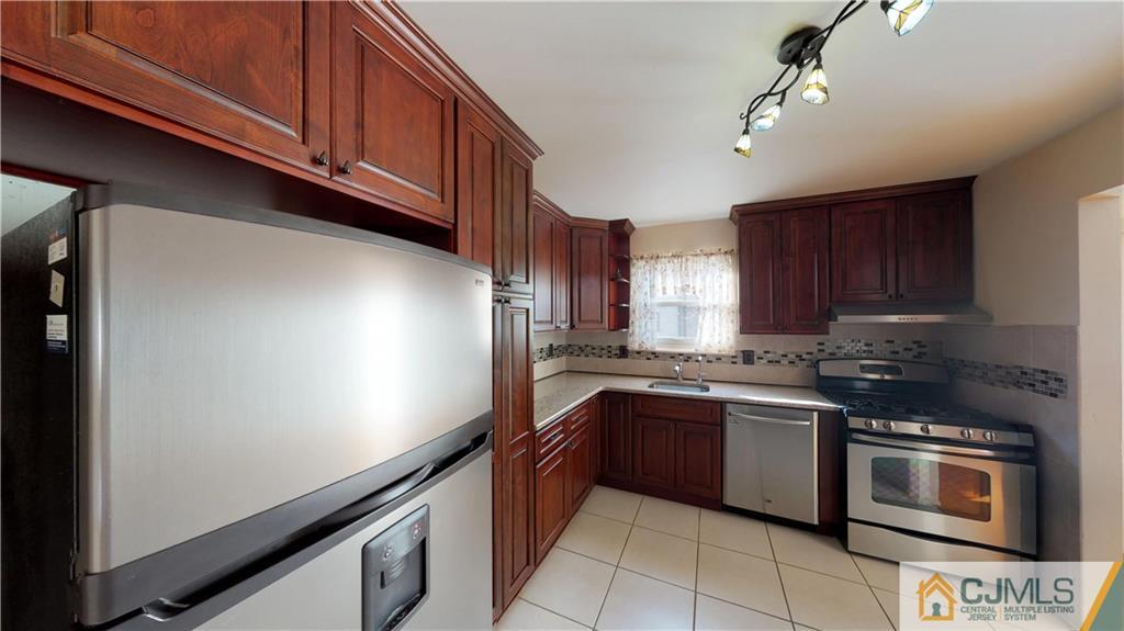 6905 Hana Road Edison, NJ 08817 - Photo 4 of 13 a kitchen with stainless steel appliances granite countertop a sink stove and microwave