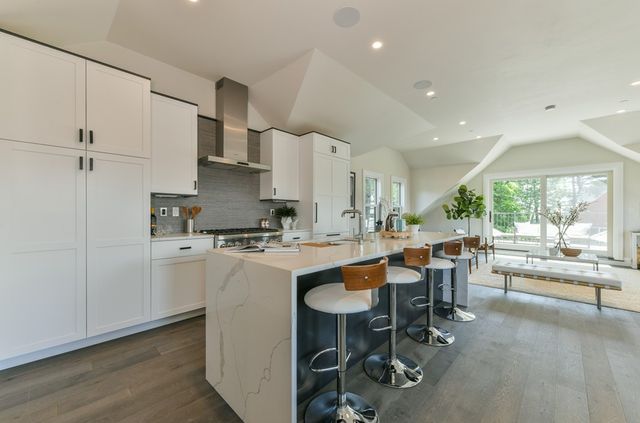 a kitchen with appliances a table and chairs in it