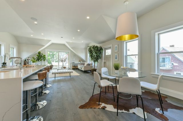a living room with furniture a table and kitchen view