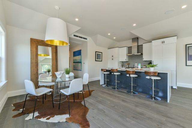 a kitchen with a dining table chairs and refrigerator