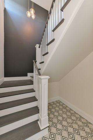 a view of staircase with white walls and chandelier
