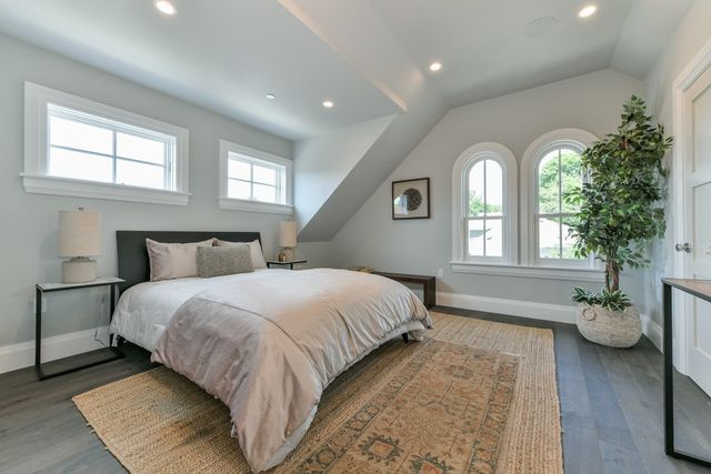 a spacious bedroom with bed and a potted plant