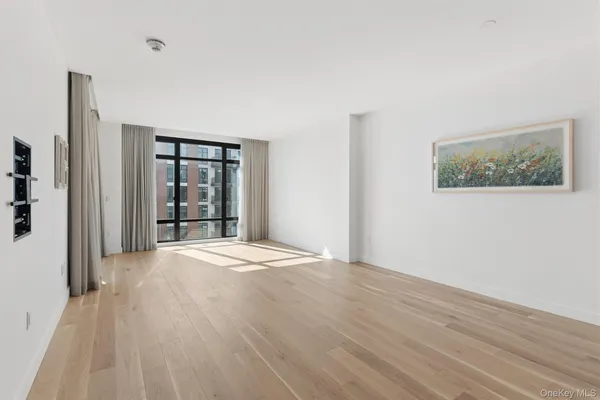 a view of an empty room with wooden floor and closet