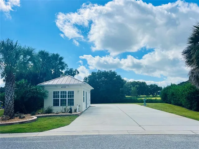 a view of a white house with a yard