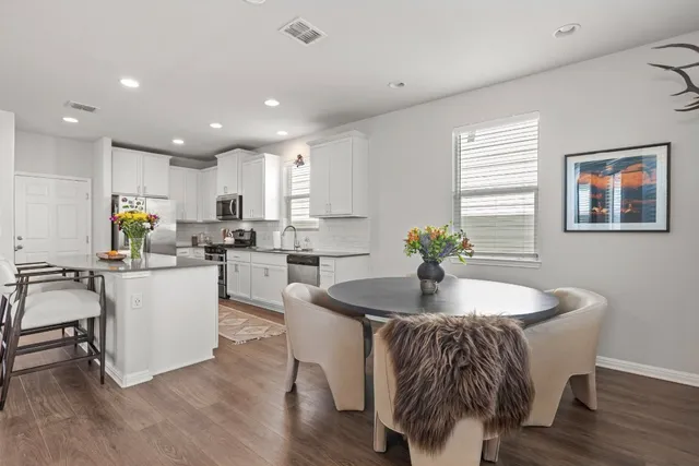a kitchen with a table chairs sink and cabinets