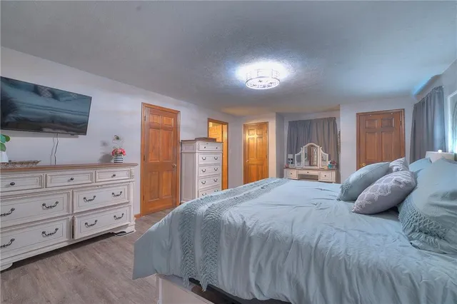 a bedroom with a large bed and a flat tv screen on dresser