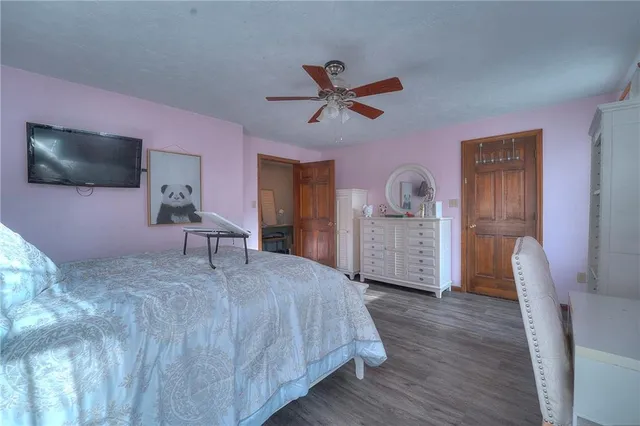 a spacious bedroom with a bed and a flat screen tv